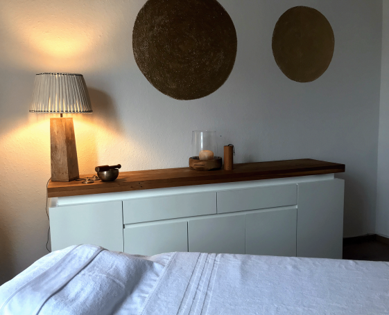 Ein modern eingerichteter Raum mit einer Kommode, Lampe und runden Wanddekoren.
